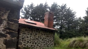 Um edifício de pedra com telhado vermelho e chaminé.