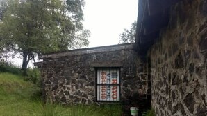 Um edifício de pedra com uma janela exibindo uma placa.