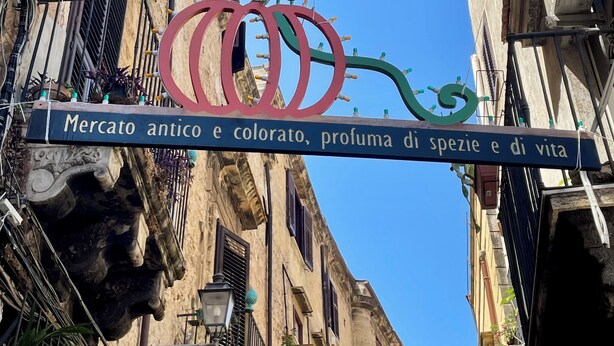 Ein Straßenschild mit Logo und Beschriftung, das auf einen historischen Marktplatz hinweist.
