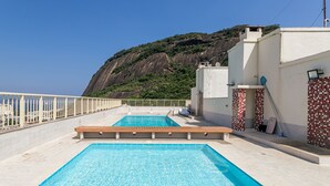 Ein Pool auf dem Dach mit Blick auf eine gebirgige Landschaft.