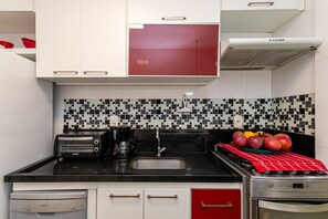 Eine kleine Küche mit Toaster, Kaffeemaschine und Spüle.