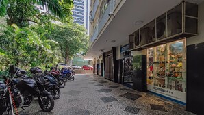 A street with parked motorcycles and a flower shop. - Sunset Urca - Conforto e lazer (Rio de Janeiro)