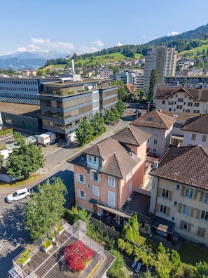 A residential area with multi-story buildings, a parking lot, and a clear view of distant mountains.
