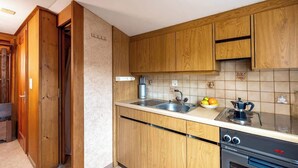 Una cocina con armarios de madera, un lavamanos doble, una estufa y un lavavajillas.