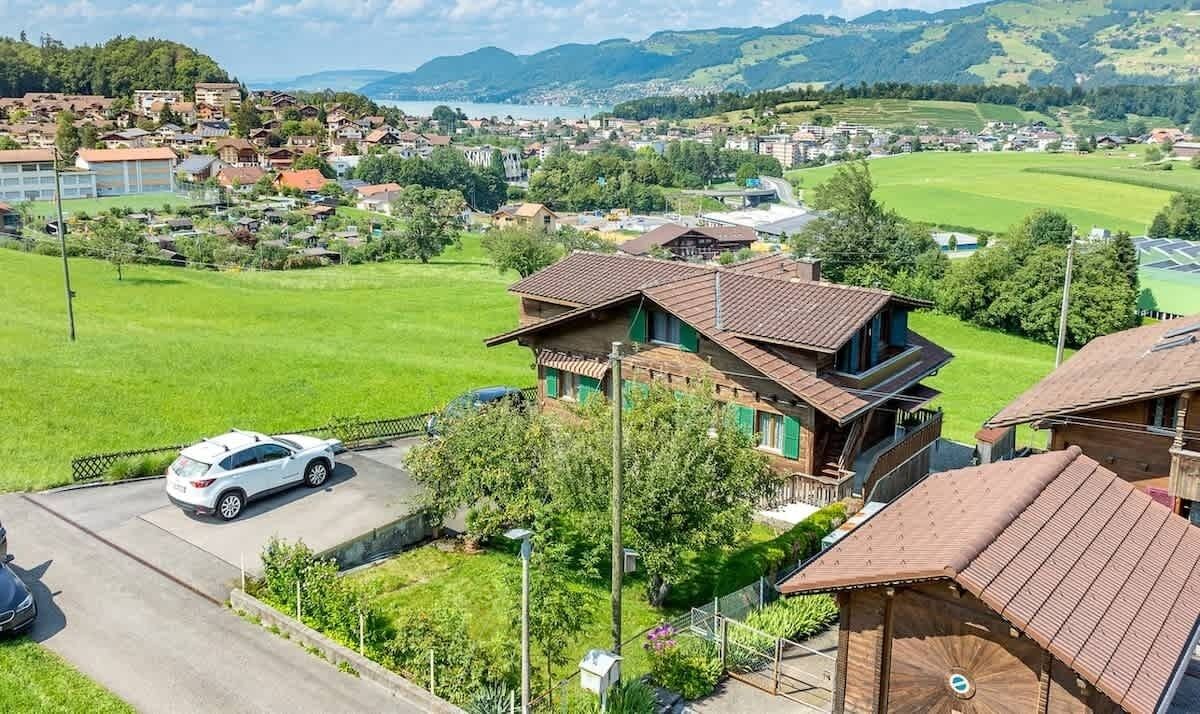 A residential area with houses, a car, and a green field.