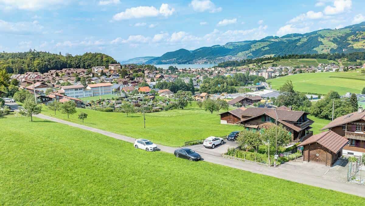 Ein Wohngebiet mit Häusern, einer Straße und einem Gewässer im Hintergrund.