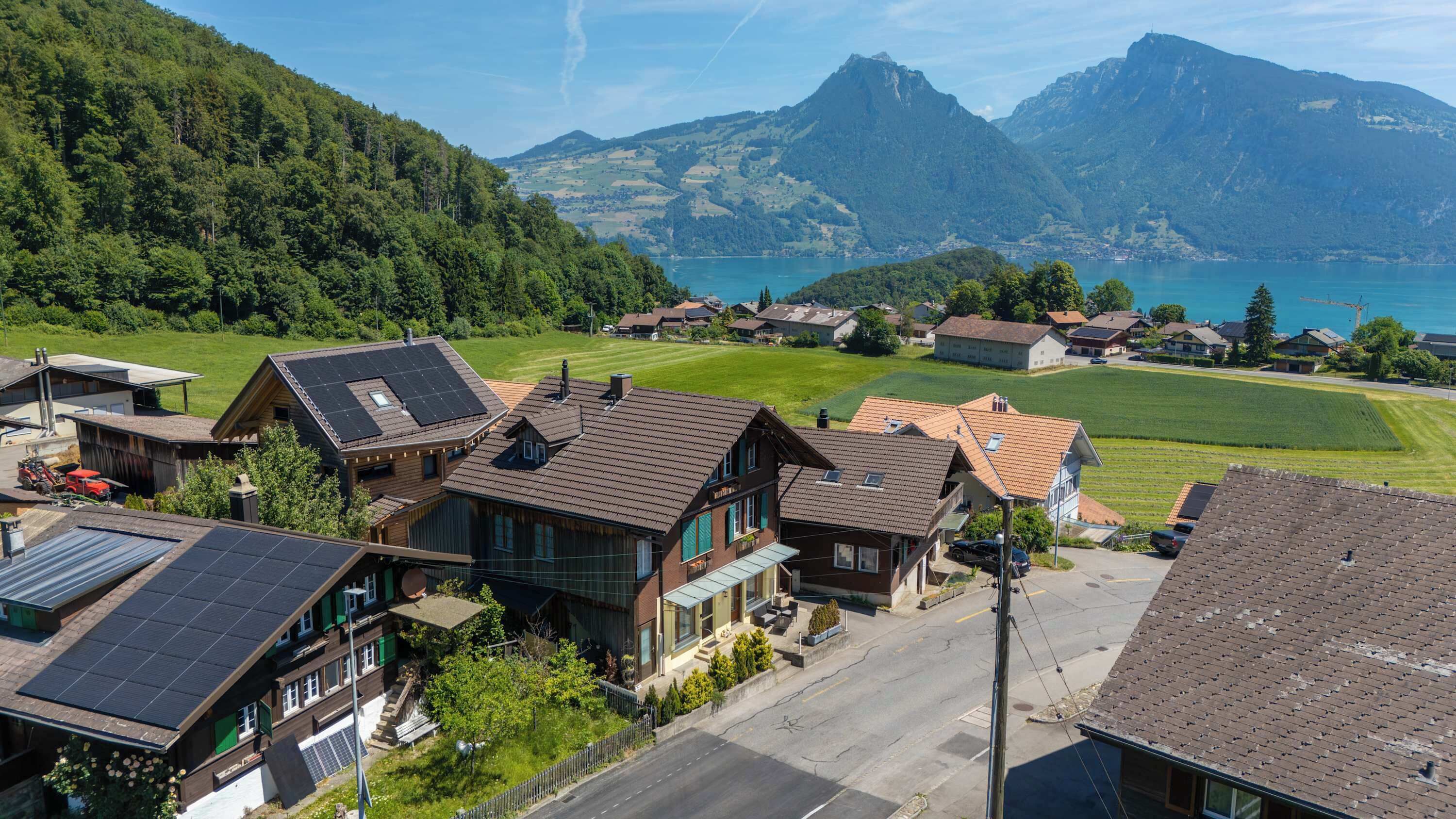 A residential area with houses, a street, and a mountainous landscape in the background.