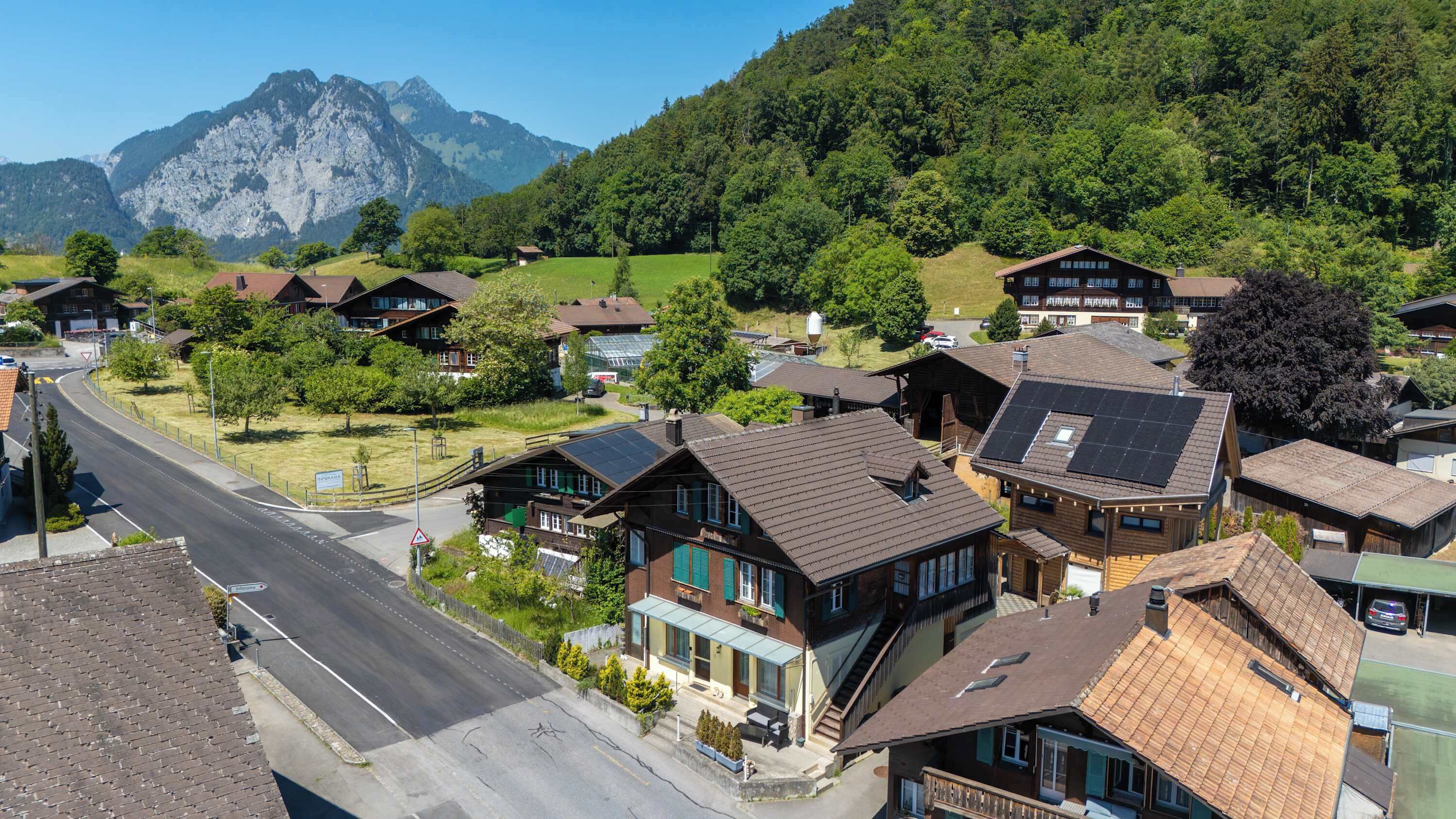 A residential area with houses, a road, and a mountain in the background.