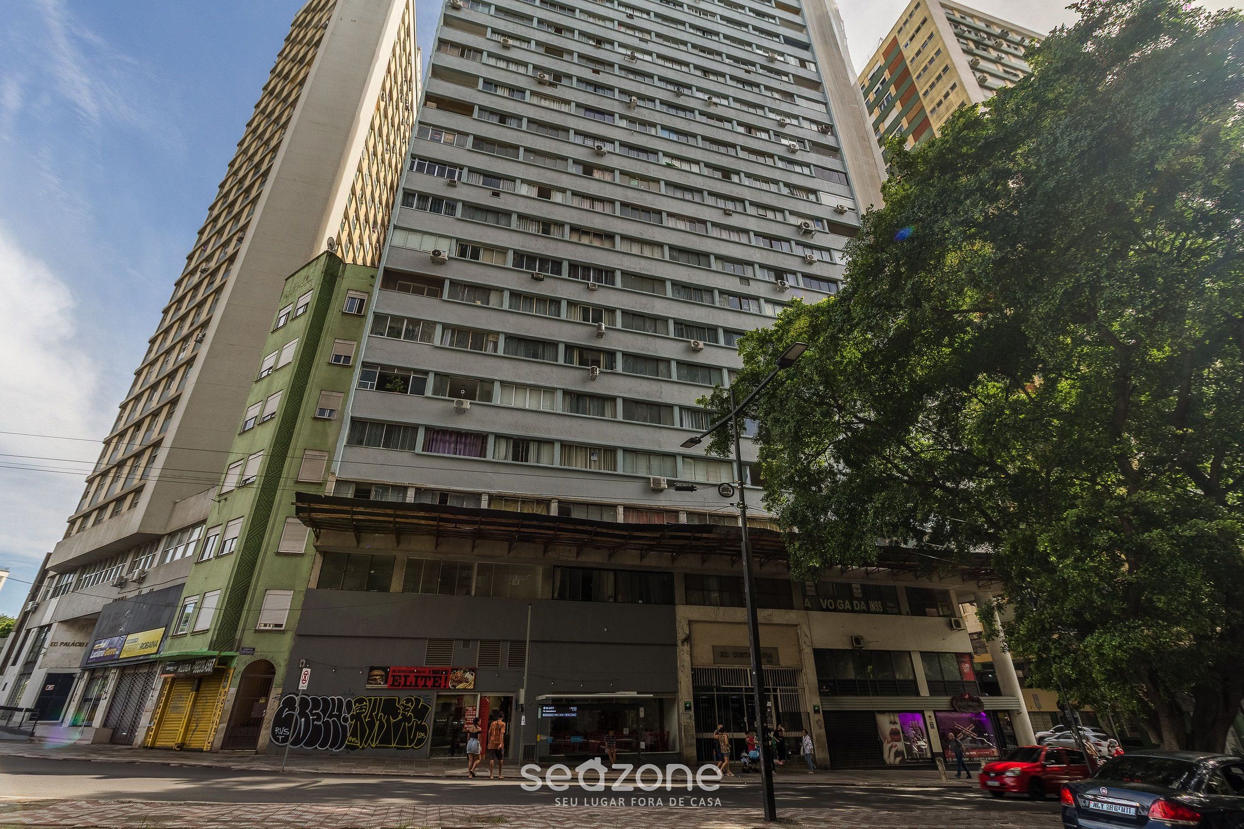 A multi-story building with a ground-level commercial space, including a restaurant and a shop.
