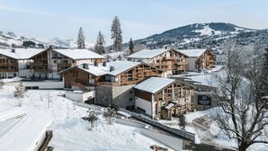 A snow-covered lodge with multiple wooden buildings, a ski slope in the background, and a clear sky. - Refined Alpine Escape near Mont Blanc (MEGEVE)