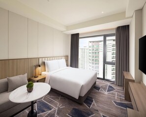 A hotel room with a bed, a sofa, a small table with a plant, a TV, and a large window with a city view. - Hyatt Place Seoul Pangyo (Seongnam)