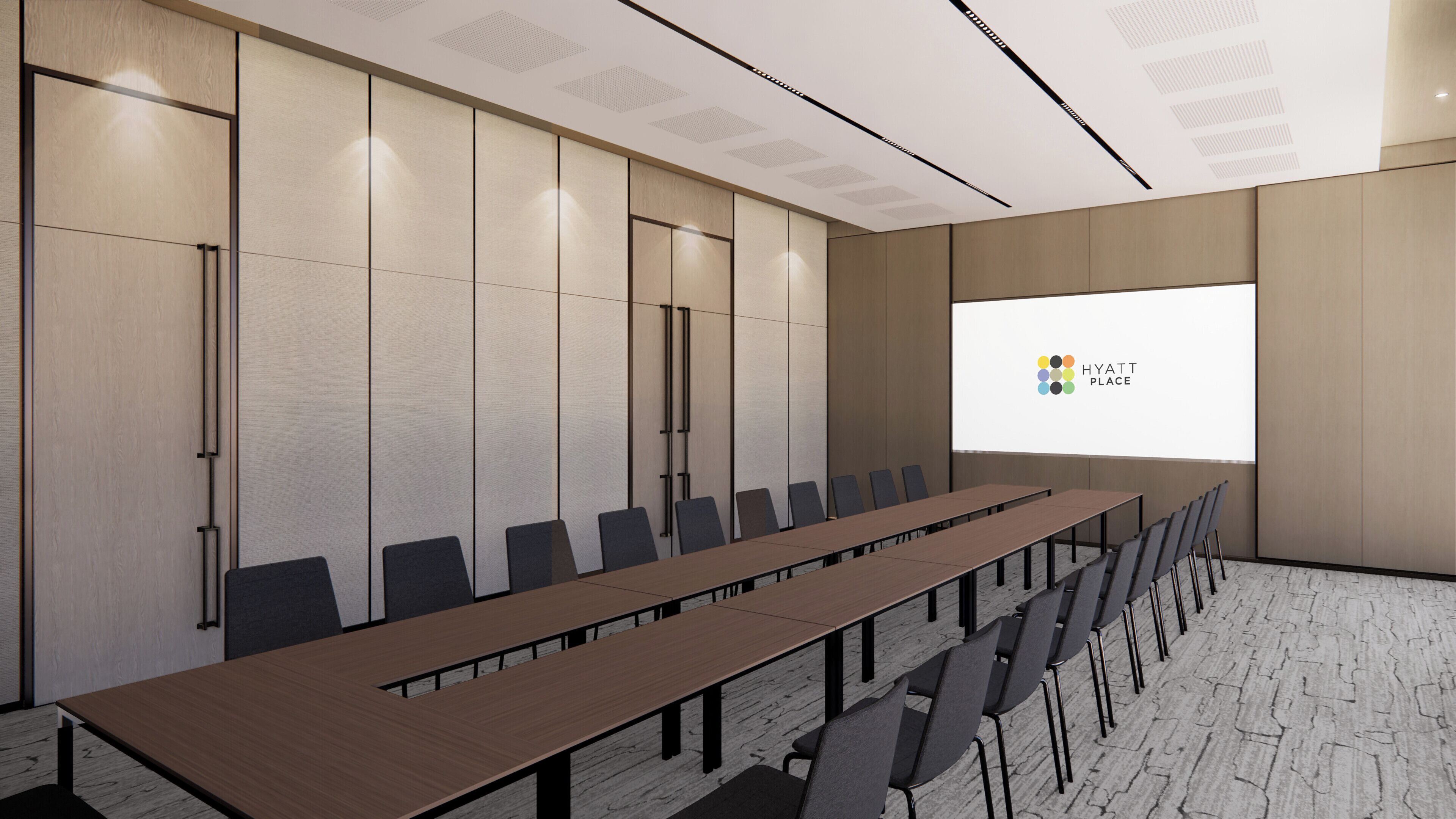Un salón de conferencias con una larga mesa y sillas, una pantalla de proyector mostrando el logotipo de Hyatt Place y un diseño de techo moderno.