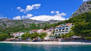 A coastal hotel with multiple buildings, a beach, and mountains in the background. - Standard Double Room With Private Bathroom 2 (Gradac)