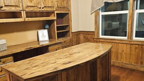 Una cocina de madera con una isla central, armarios de madera y una ventana con cortina.