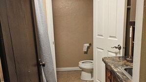 Un baño con inodoro, lavamanos y zona de ducha.