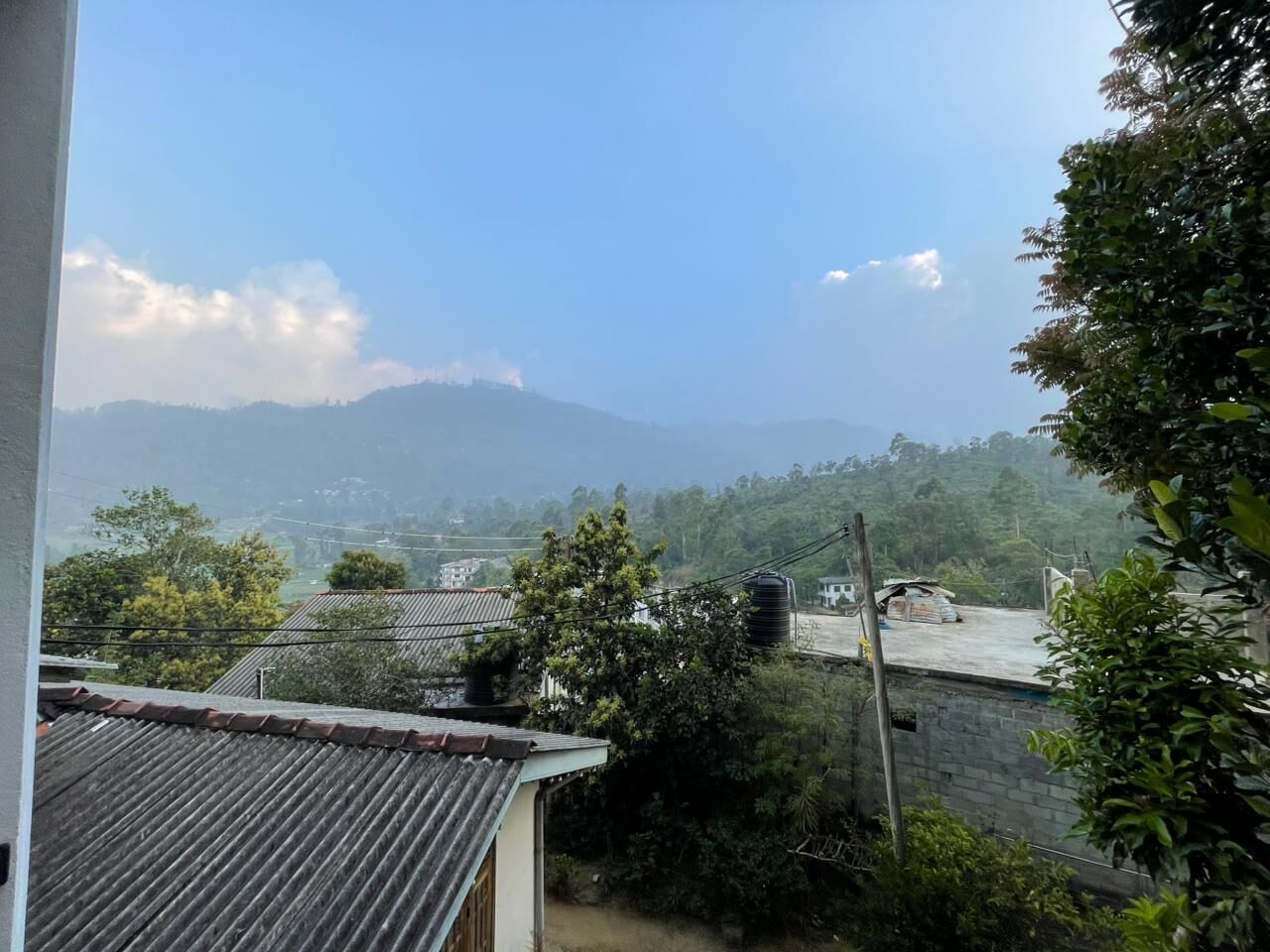 A residential area with houses, a water tank, and a mountain in the background.