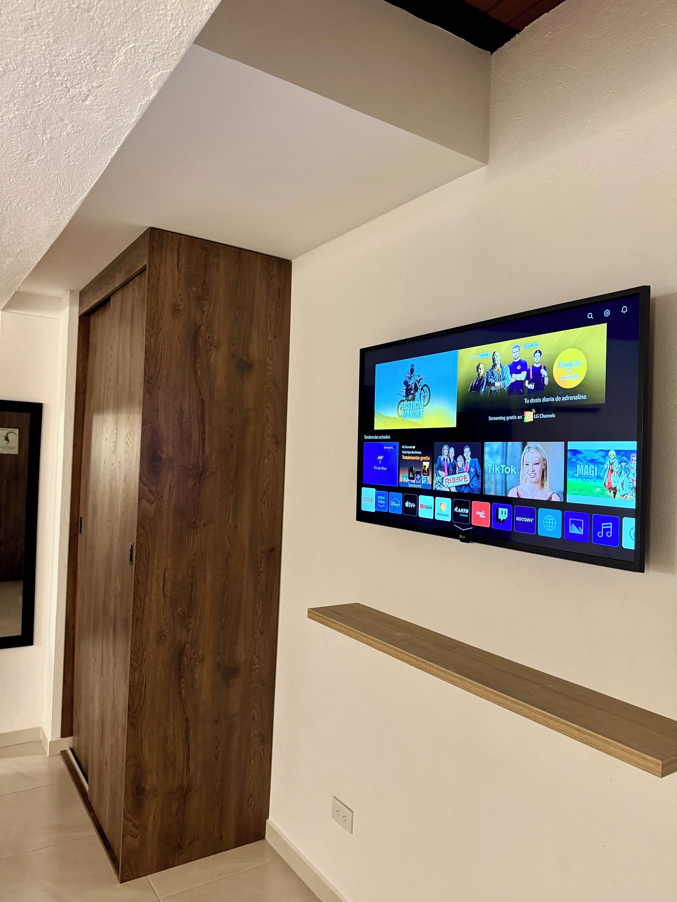 Ein Flachbildfernseher an der Wand zeigt verschiedene Streaming-Apps.