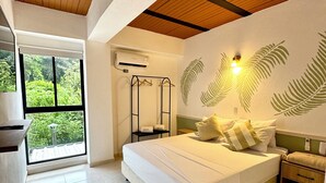 A bedroom with a large bed, a wardrobe, a hanging clothes rack, and a window with an air conditioning unit. - Ivanna Hotel Campestre - Santa Fe de Antioquia (Santa Fe de Antioquia)