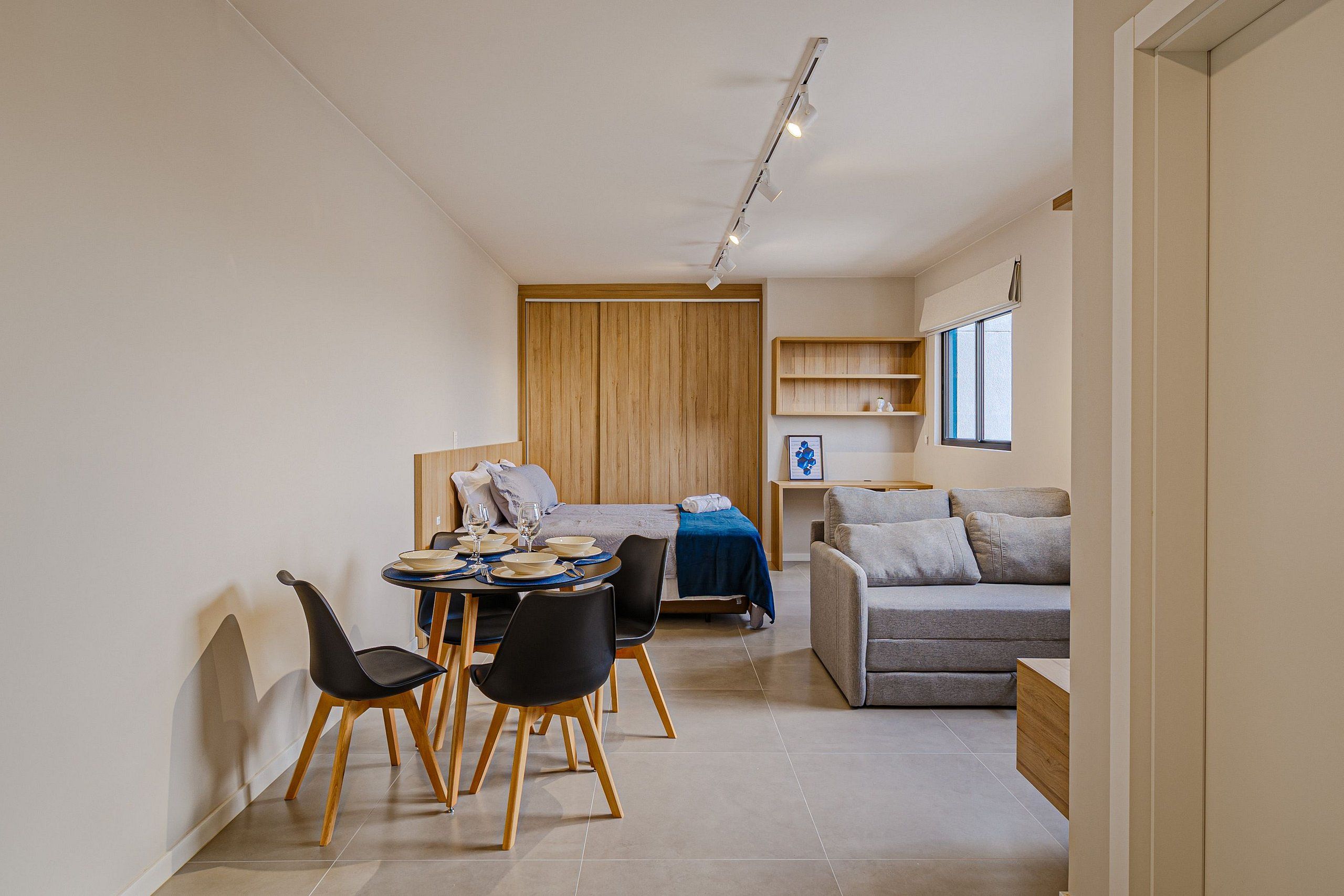 Un interior moderno con comedor, sofá y armario de madera.