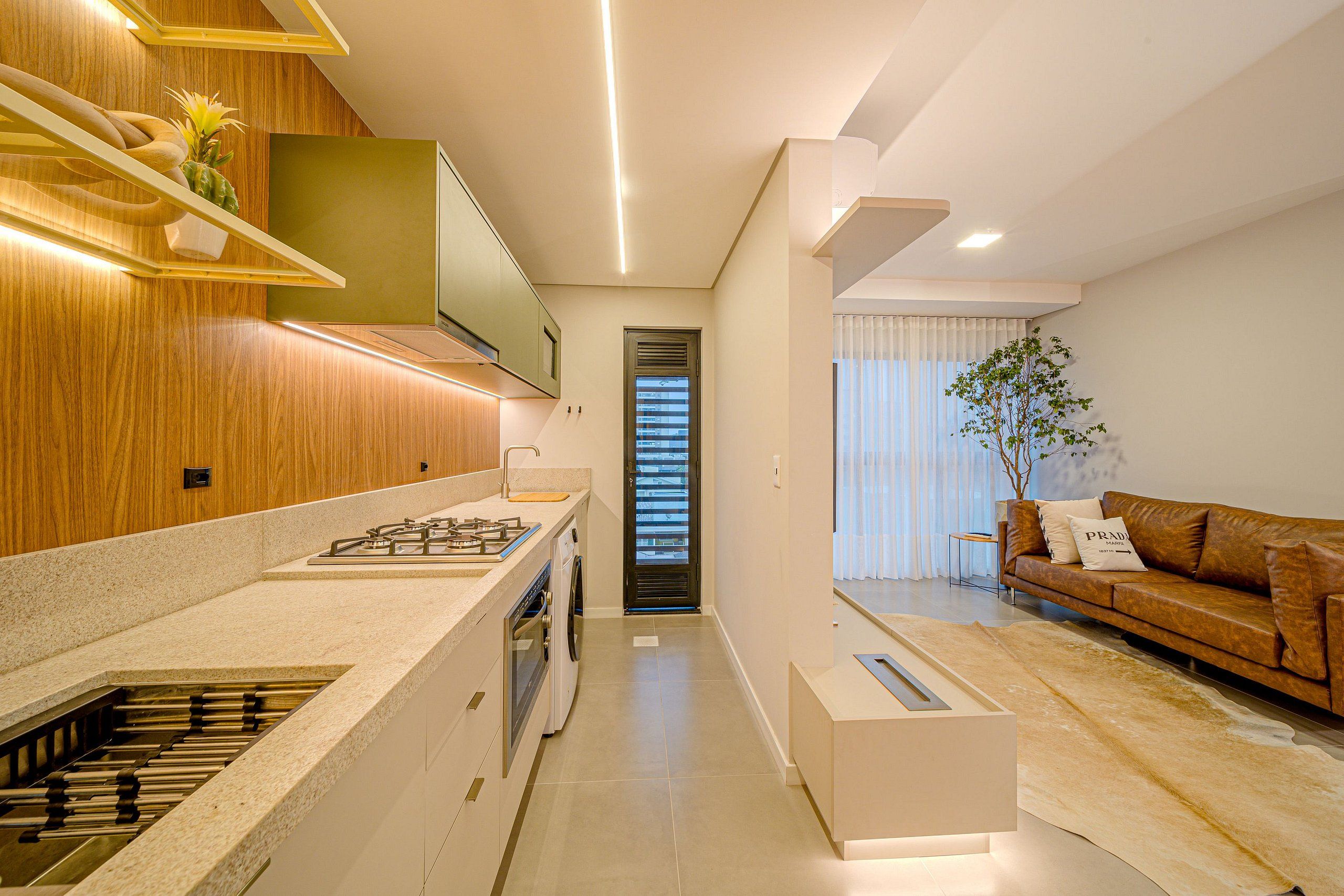 Una cocina moderna con horno integrado, lavadora y comedor con sofá y mesa de centro.