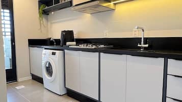 Una cocina moderna con electrodomésticos integrados, un tapete con estampado blanco y negro y una encimera negra.