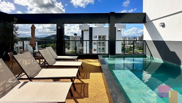 A rooftop pool area with sun loungers and a view of the city. - Mingus Residencial Flipchave MIN000 (Joinville)
