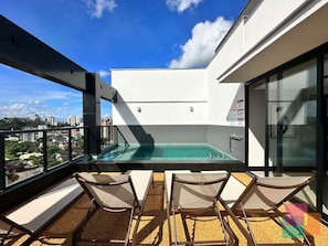 A rooftop terrace with a pool, lounge chairs, and a city view. - Mingus Residencial Flipchave MIN000 (Joinville)