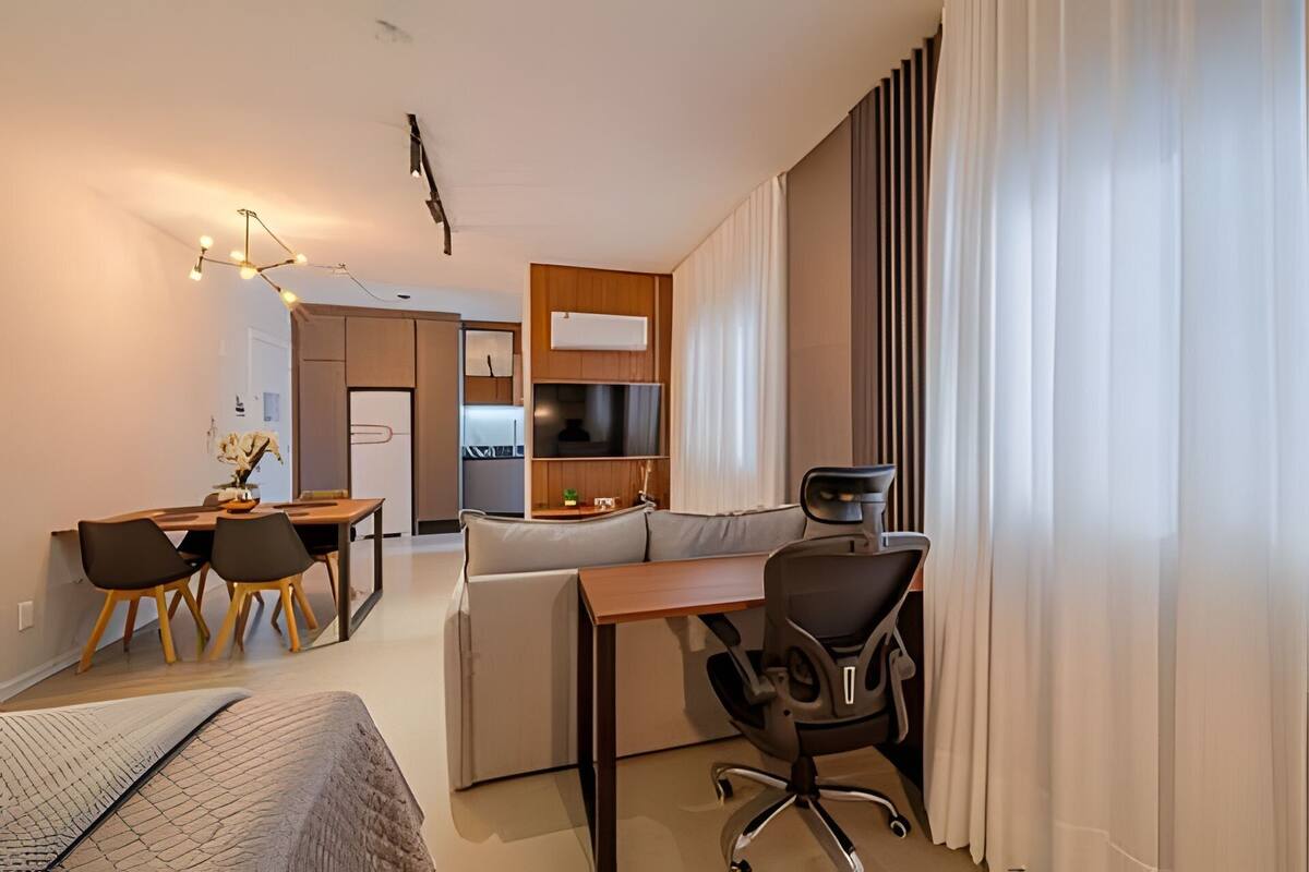 Une chambre d’hôtel moderne équipée d’un coin repas, d’un canapé, d’un bureau et d’une télévision.