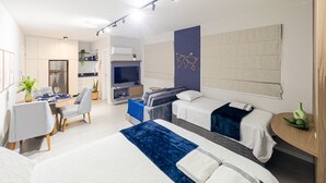 A modern hotel room with a bed, a desk, a chair, a TV, and a large window. - Mingus Residencial Flipchave MIN000 (Joinville)