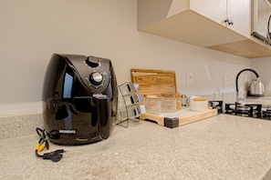 A kitchen with a coffee maker, a wooden cutting board, and a kettle. - Mingus Residencial Flipchave MIN000 (Joinville)