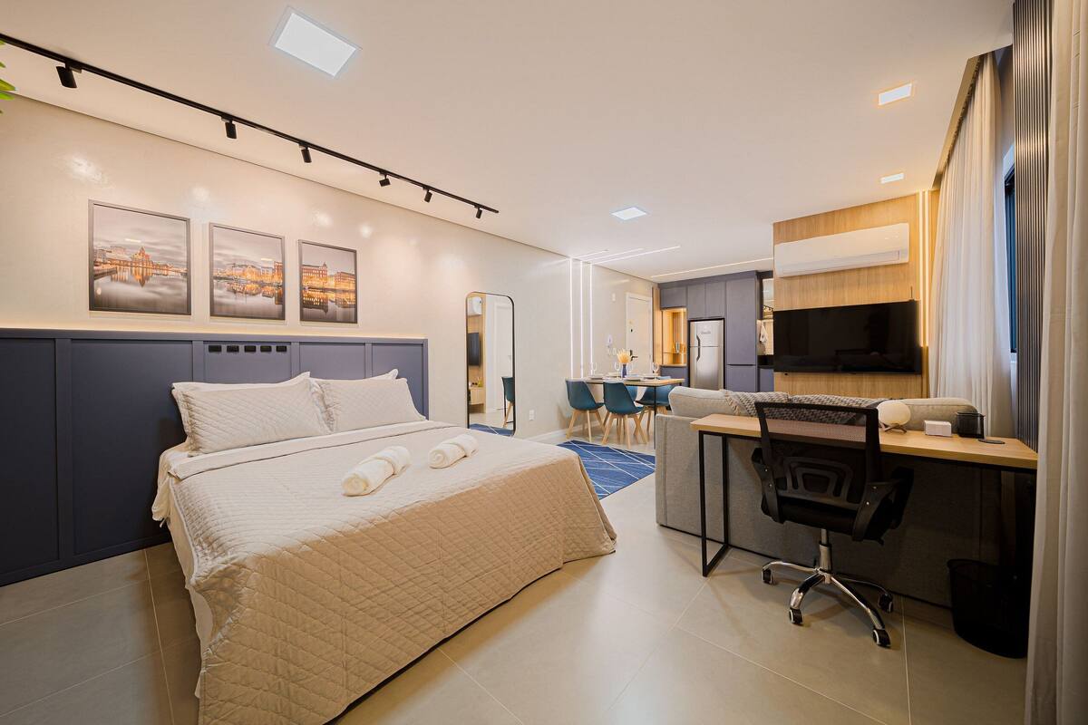 Une chambre d’hôtel moderne équipée d’un lit, d’un bureau, d’une chaise et d’un coin repas.