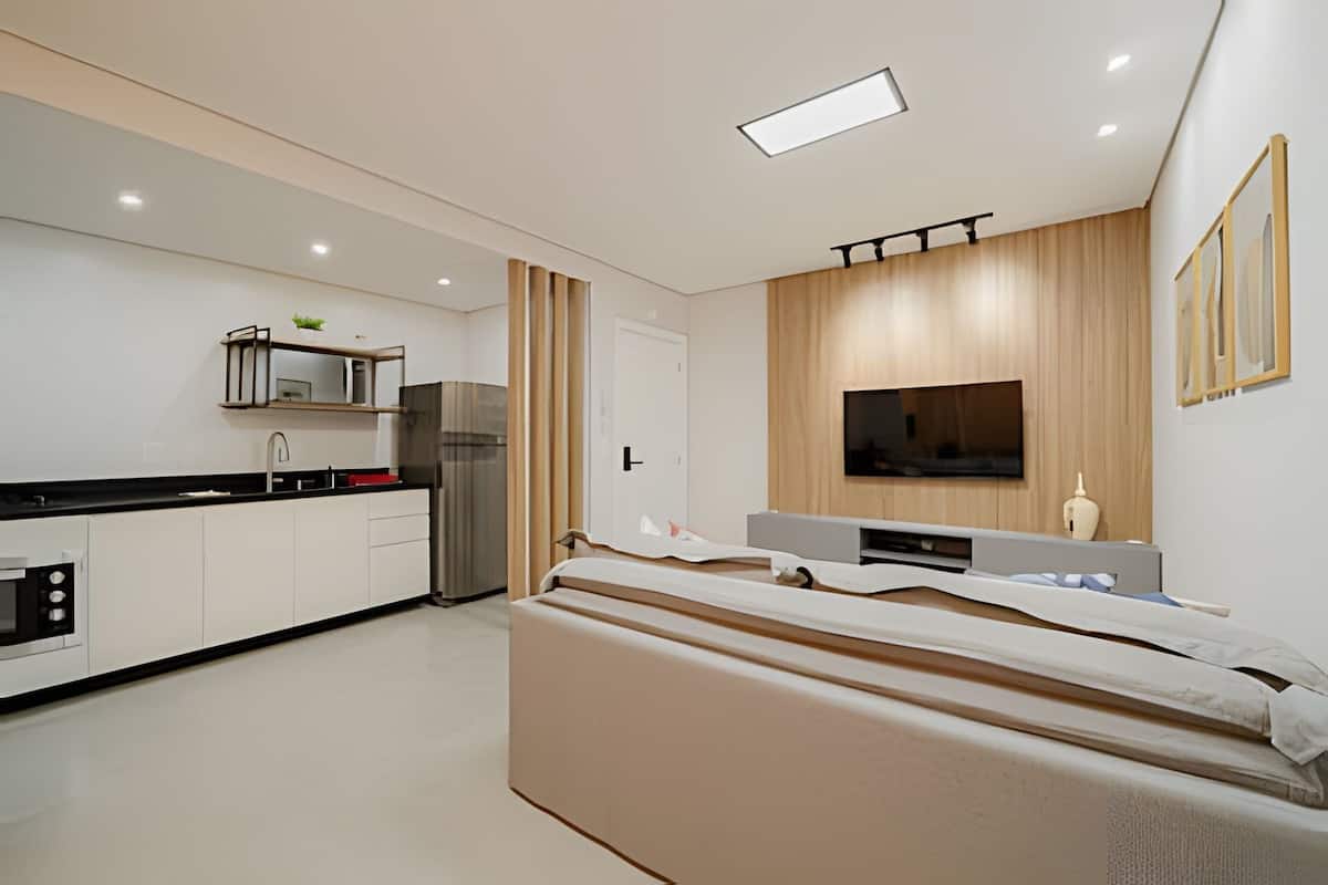Une cuisine moderne équipée d’un four à micro-ondes, d’un réfrigérateur et d’un mur recouvert de panneaux en bois.