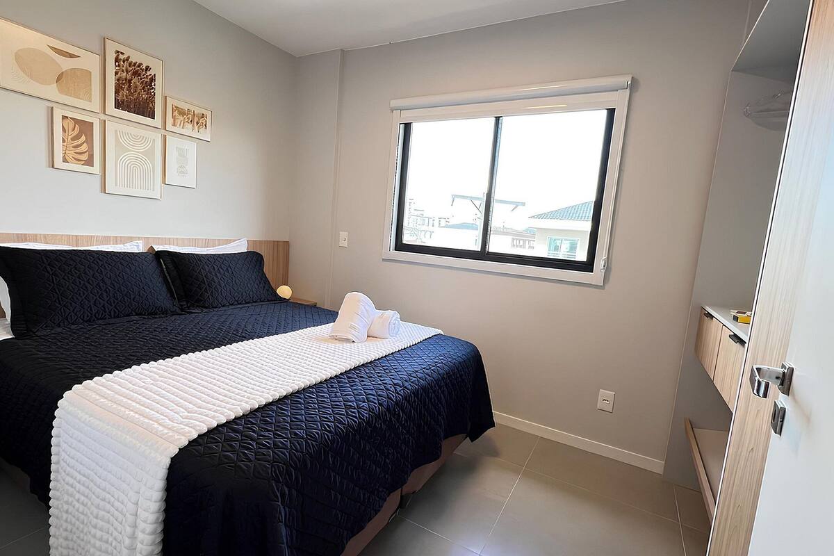 Une chambre à coucher avec un lit, une fenêtre et des œuvres d’art murales.