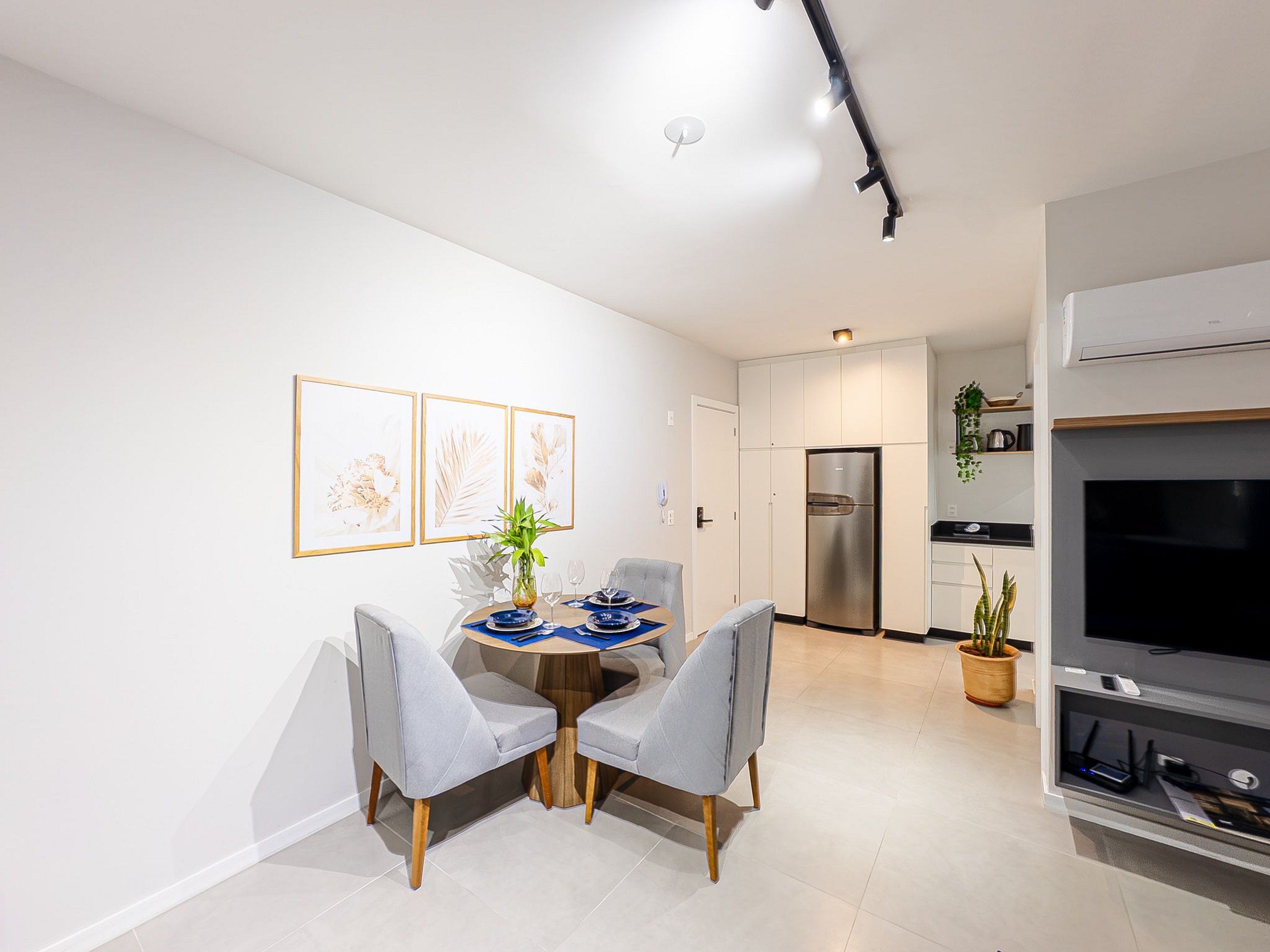Una cocina moderna con un refrigerador empotrado y un televisor de pantalla plana.