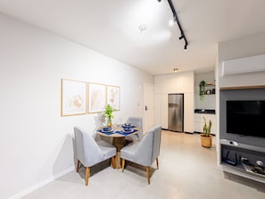 A modern kitchen with a built-in refrigerator and a flat-screen TV. - Mingus Residencial Flipchave MIN000 (Joinville)
