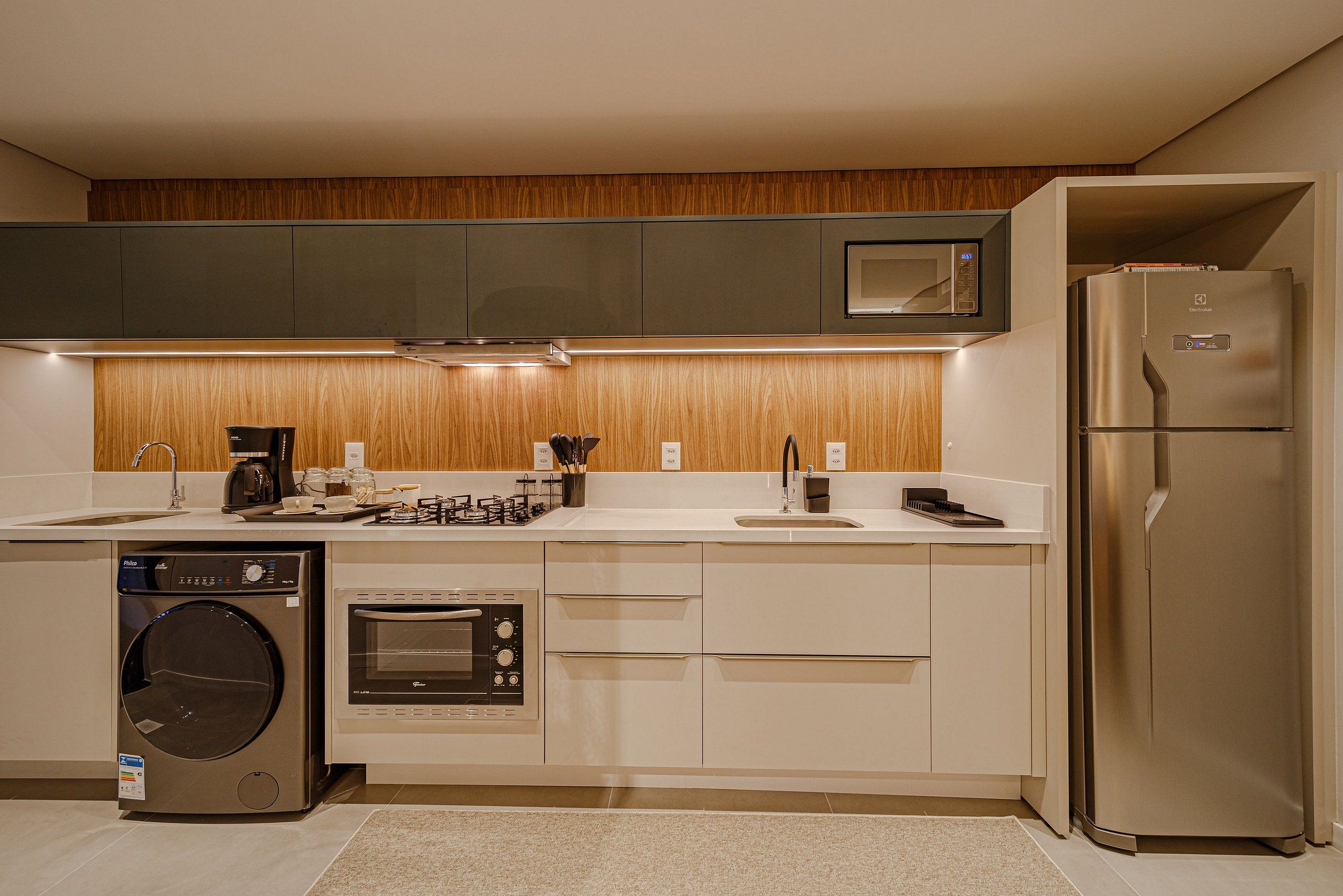 A modern kitchen with built-in appliances, a microwave, oven, and a refrigerator.