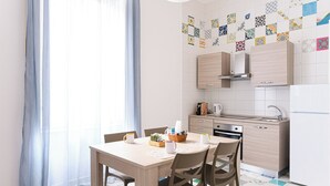 A modern kitchen with light wood cabinets, a built-in oven, and a white refrigerator. - Apartment in Marechiaro Int 13 (Napoli)