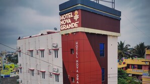A multi-story hotel building with a prominent sign reading "HOTEL NOVA GRANDE". - Nova Grande' (Hosur)