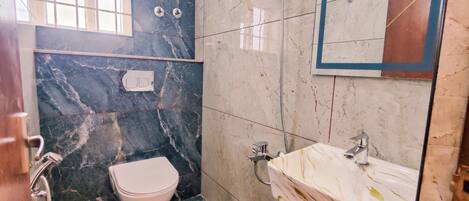 Un baño con inodoro, lavamanos y ducha.