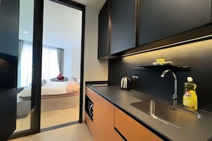 A modern kitchen with a sink, kettle, and a bottle of dish soap. - EDGE Central Pattaya Oasis (Pattaya)