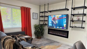 A living room with a flat-screen TV mounted on the wall, a sofa, a coffee table, and a potted plant. - 3-bedroom house in beautiful Citrus Heights (Citrus Heights)
