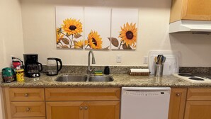 A kitchen with granite countertops, wooden cabinets, a dishwasher, and a coffee maker. - 3-bedroom house in beautiful Citrus Heights (Citrus Heights)