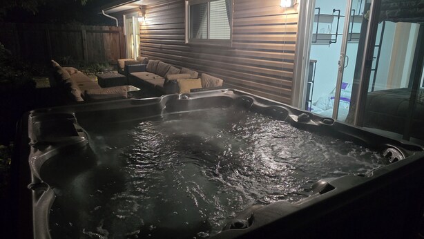 A hot tub in front of a house with a covered patio and a sliding glass door leading to a bedroom. - 3-bedroom house in beautiful Citrus Heights (Citrus Heights)