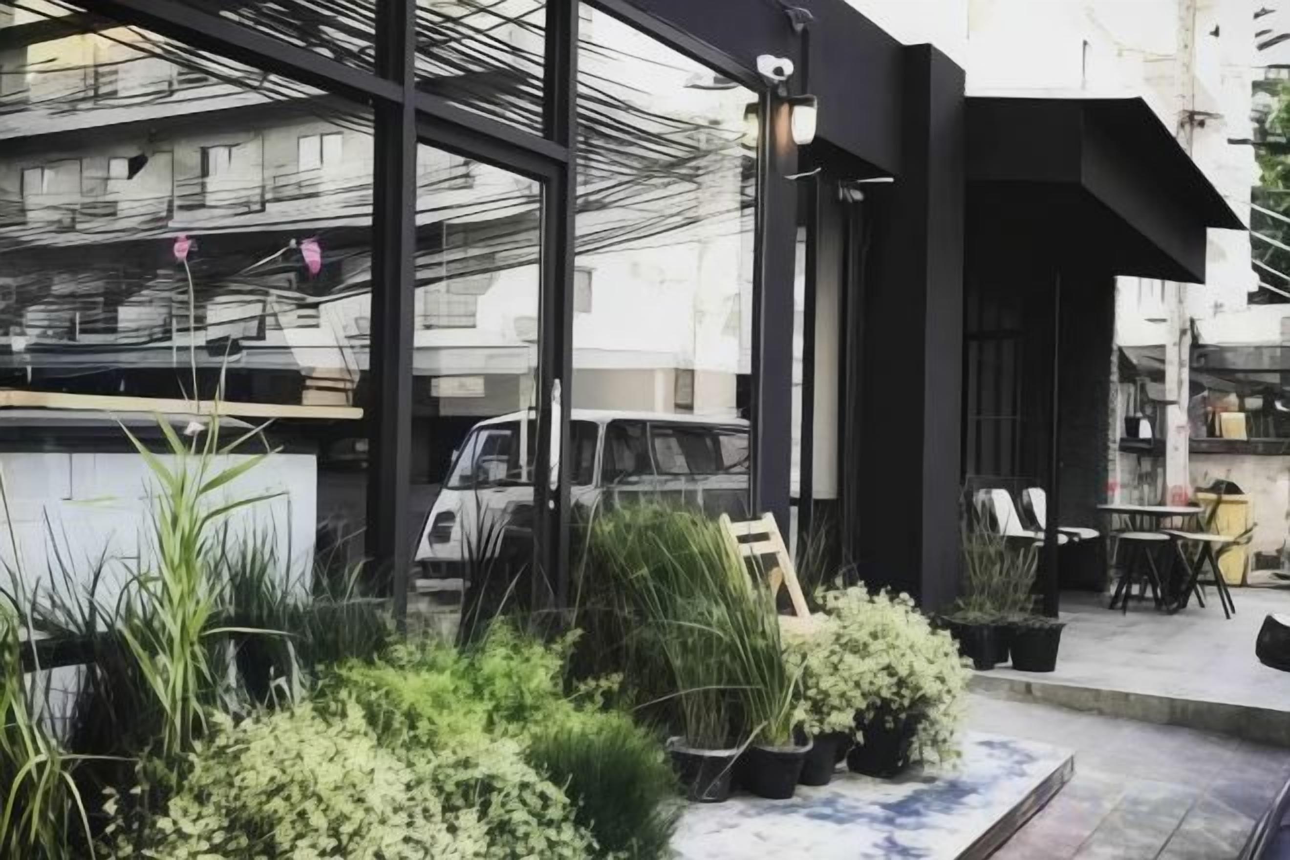 An outdoor seating area with potted plants, a table, and chairs.