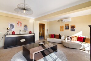 A modern living room with a sofa, a coffee table, and artwork on the walls. - Villa 'Picota' with Sea View, Wi-Fi and Air Conditioning (Tavira)