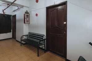 Un pasillo con un banco, una puerta de madera y un cuadro colgado en la pared.