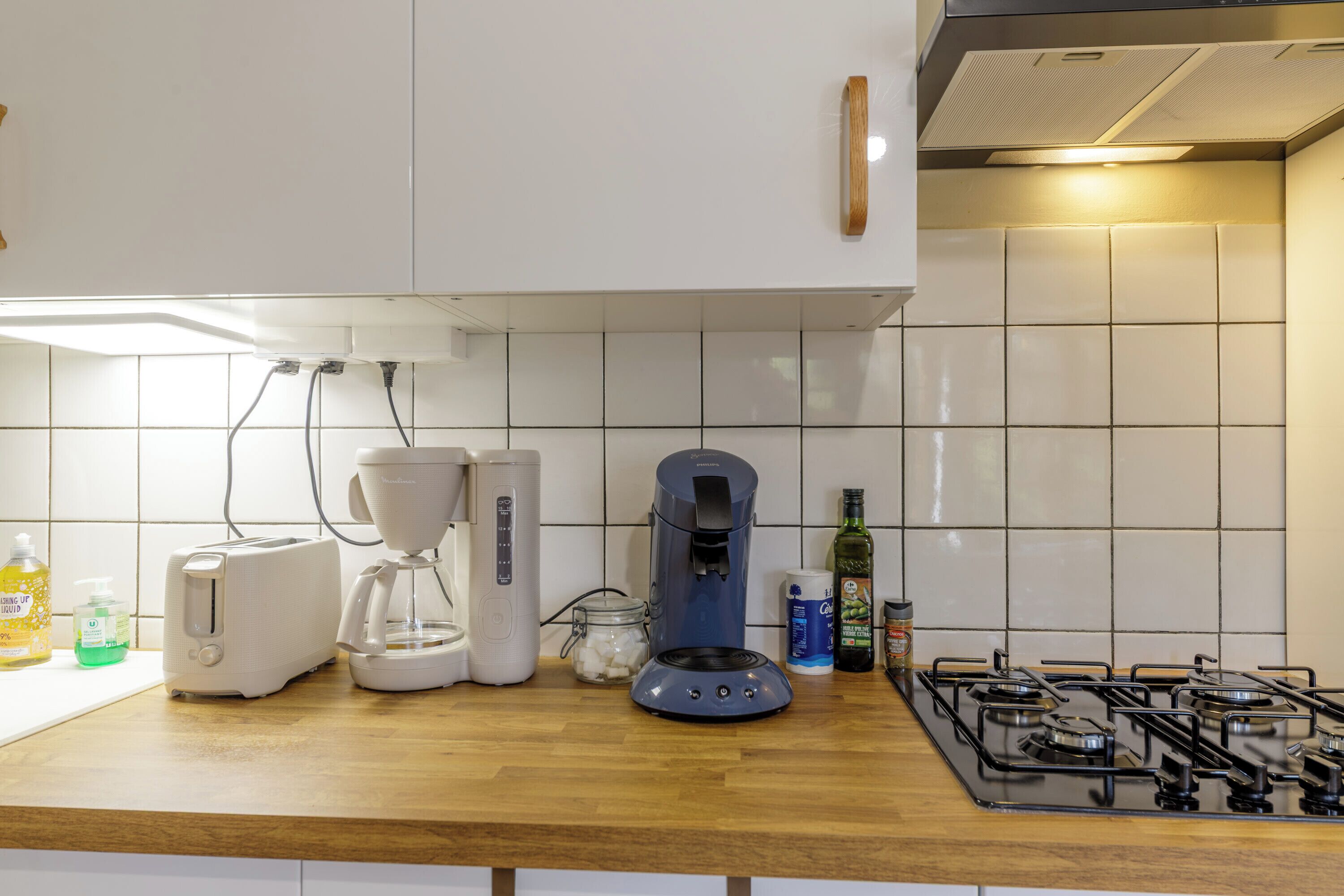 Eine Küche mit Toaster, Kaffeemaschine und Gaskochherd.