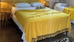 A hotel room with a wooden ceiling, a bed with a yellow blanket, two bedside tables with lamps, and a window with curtains. - Casamares beach in Ipioca, Maceió, Angra de Ipioca condominium, Hibiscus Beach Club (Maceió)