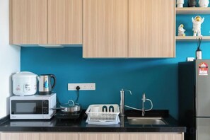 A kitchen with wooden cabinets, a microwave, a kettle, a sink, and a refrigerator. - Urban Suite@Midhills Genting Highlands (Free WiFi) (Genting Highlands)