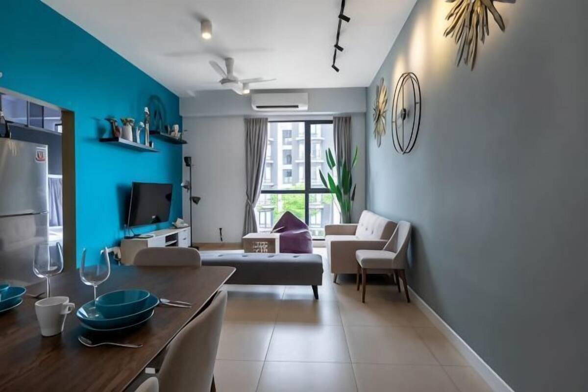 Een moderne woonkamer met een eethoek, een bank, een televisie en een groot raam.